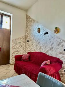 a living room with a red couch in a room at Da Raffaella affittacamere in Cicciano +36 photos