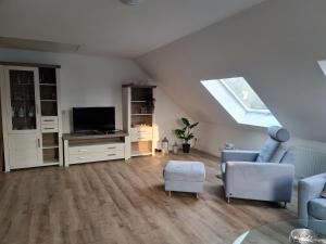 ein Wohnzimmer im Dachgeschoss mit einem Dachfenster und einem TV in der Unterkunft Treeneperle in Schwabstedt
