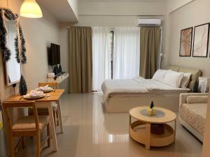 a bedroom with a bed and a living room at Crosswinds Tagaytay Holiday Home by KTCH in Tagaytay