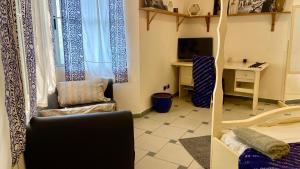 a living room with a couch and a chair and a desk at Le Colibri Guesthouse in Cotonou