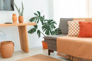 a living room with a couch and a plant at Conforto e Charme, Casa a 360m da Areia in Porto Seguro +31 photos