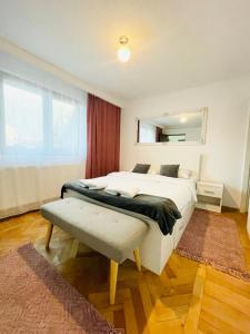 ein Schlafzimmer mit einem großen weißen Bett und einem Fenster in der Unterkunft Londof Villa with panoramic view in Braşov