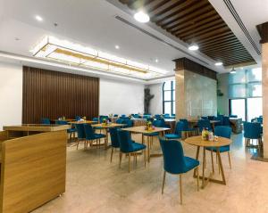 a dining room with tables and blue chairs at Emaar International in Mecca