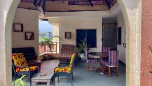an outdoor patio with colorful chairs and a table at Le Colibri Guesthouse in Cotonou