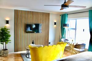 ケープタウンにあるYellow Couch Studio Apartment 1 KingBedのリビングルーム(黄色い椅子付)、窓