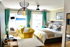 ケープタウンにあるYellow Couch Studio Apartment 1 KingBedのベッドと椅子と窓のある寝室