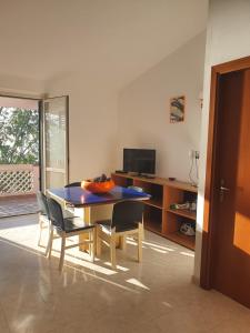 a dining room with a blue table and chairs at VILLA MARELUNA - near the beach , family residence pet friendly ! in Capo Vaticano