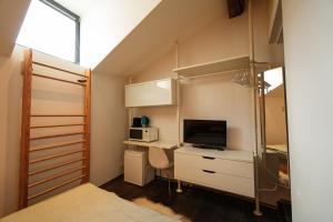 a bedroom with a bed and a desk with a television at Dans ma bulle in Sion