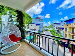 a bench on a balcony with a view of a street at Le House Cat Ba in Cat Ba