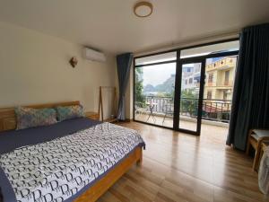 a bedroom with a bed and a large window at Le House Cat Ba in Cat Ba