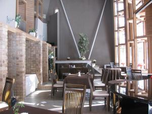 a restaurant with tables and chairs and windows at La Forest De Nome Karuizawa in Karuizawa