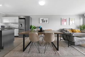a kitchen and living room with a table and a couch at Two Bedroom Luxury Apartment, Century City - BackUp Power in Cape Town
