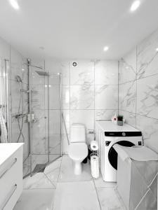 a white bathroom with a toilet and a shower at Lyxig Stadsro och Utrymme villa i Malmö in Malmö +17 photos
