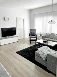 a living room with a couch and a tv at Lyxig Stadsro och Utrymme villa i Malmö in Malmö