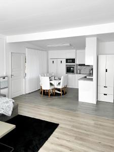 a white kitchen and dining room with a table and chairs at Lyxig Stadsro och Utrymme villa i Malmö in Malmö