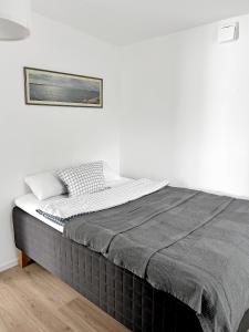 a bed in a white room with a picture on the wall at Lyxig Stadsro och Utrymme villa i Malmö in Malmö