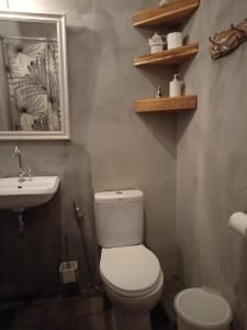 a bathroom with a white toilet and a sink at Shelter Hostel Malang in Malang