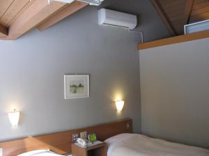 um quarto com uma cama e duas luzes na parede em La Forest De Nome Karuizawa em Karuizawa