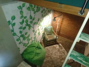 a room with a chair and a plant on the wall at Shelter Hostel Malang in Malang