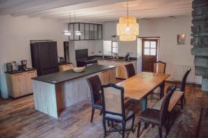 a kitchen with a wooden table and a dining room at Domaine de Maisonneuve in Sugères