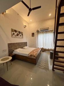 a bedroom with a bed and a ceiling fan at Aranyaa Cottage Homestay Vrindavan in Jait