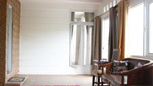 a living room with a couch and windows at Rumah Marmut Pakancilan in Tagalbato