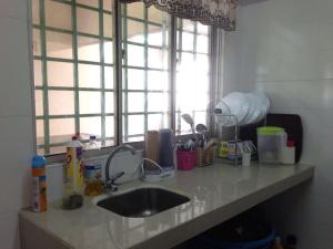 un comptoir de cuisine avec un évier et une fenêtre dans l'établissement Noah's Homestay, à Shah Alam