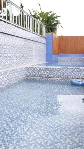 a swimming pool with a blue and white tile floor at Rumah Marmut Pakancilan in Tagalbato