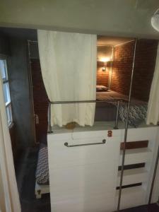 a small room with a bunk bed and a white cabinet at Shelter Hostel Malang in Malang