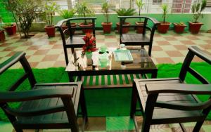 a table with four chairs and a table with flowers on it at Ghala Residency in Munnar