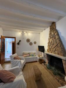 a living room with a fireplace and a couch at Villa rural sXIX Luz tranquilidad y naturaleza in Blanca