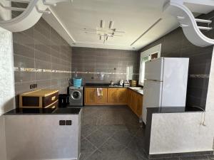 a kitchen with a refrigerator and a microwave at Saidia Appartement a Louer in Saïdia