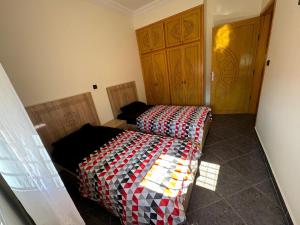 a bedroom with a bed with a checkered blanket at Saidia Appartement a Louer in Saïdia
