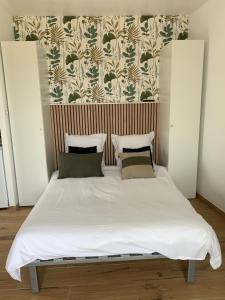 a bed with white sheets and pillows in a bedroom at Studio neuf porticcio in Porticcio