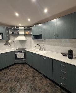 a kitchen with green cabinets and a sink and a stove at Villa Alexa in Borovets