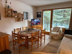 a dining room with a table and chairs and a couch at Le chardon bleu in La Salle-les-Alpes