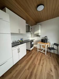 cocina con armarios blancos y suelo de madera en Best Frankfurt Apartments, en Frankfurt