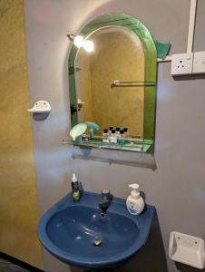 a bathroom with a blue sink and a mirror at Turtle Village Guest Mirissa in Mirissa