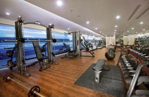 einen Fitnessraum mit Laufbändern und Maschinen in einem Zimmer in der Unterkunft ASTON Kupang Hotel & Convention Center in Kupang