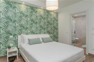 a bedroom with a large bed with a green leafy wall at ARMONIA Guest House in Passo Corese