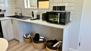 a kitchen with a microwave on a counter with baskets at Obs Centre Luxe Loft in Cape Town