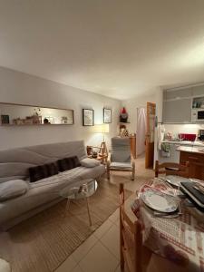 a living room with a couch and a table at Le chardon bleu in La Salle-les-Alpes