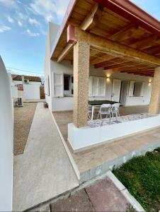 a patio with a table and chairs in a house at Villa Nido dei Passeri in Calasetta