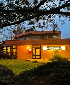 BüchenbronnにあるMinihotel Büchenbronnの大きな窓のある大きなオレンジ色の建物