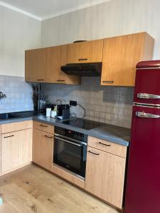 a kitchen with wooden cabinets and a red refrigerator at Apartment Vita Cittadina in Klagenfurt