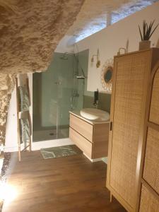 a bathroom with a shower and a wooden cabinet at La Grotte du Bonheur in Cangey