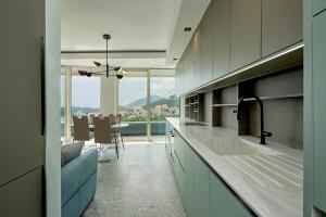 a kitchen with a table and a view of the city at Панорамная квартира на первой линии моря Skyline Resort, Becici, Budva in Becici