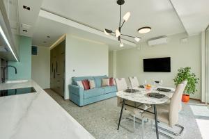 a living room with a table and a blue couch at Панорамная квартира на первой линии моря Skyline Resort, Becici, Budva in Becici