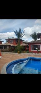 a large blue swimming pool in front of a house at Casa Duplex Vista Mar 01 in Porto Seguro