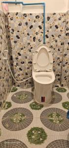 Habitación con suelo de baldosa y baño con aseo. en INN RIVERSIDE HOSTEL Pb, en Pakbeng